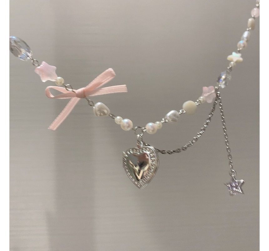 Collier avec pendentif en forme de cœur et nœud en fausses perles