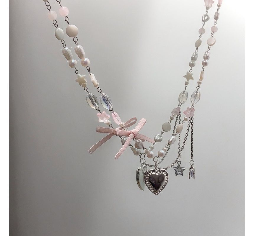 Collier avec pendentif en forme de cœur et nœud en fausses perles