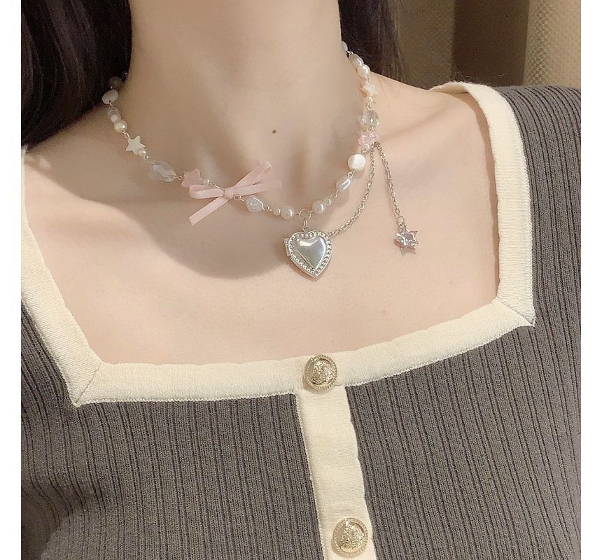 Collier avec pendentif en forme de cœur et nœud en fausses perles