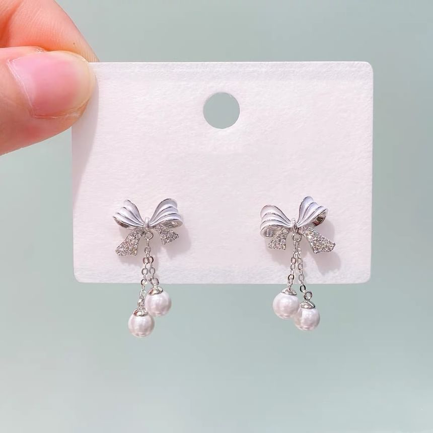 Boucles d'oreilles pendantes en fausses perles avec nœud en strass