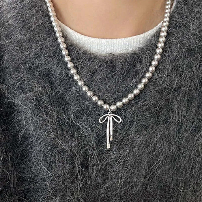 Collier de perles avec pendentif en forme de nœud