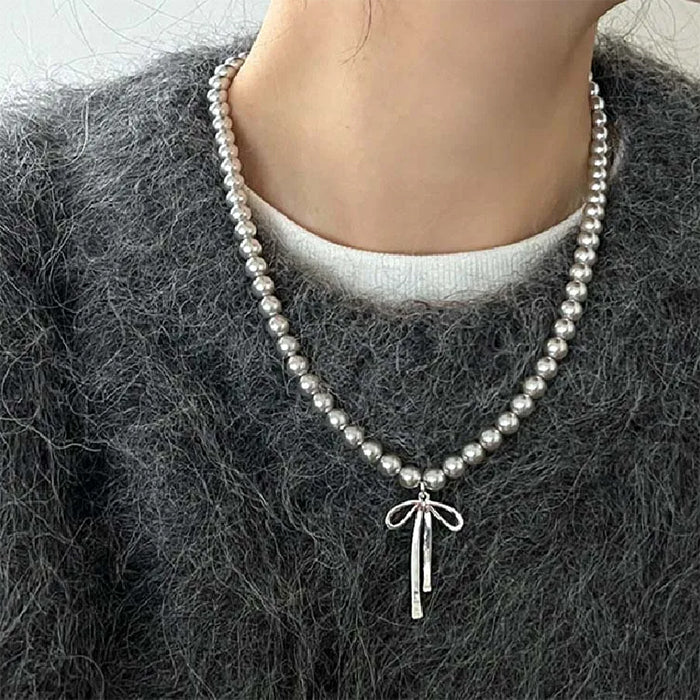 Collier de perles avec pendentif en forme de nœud