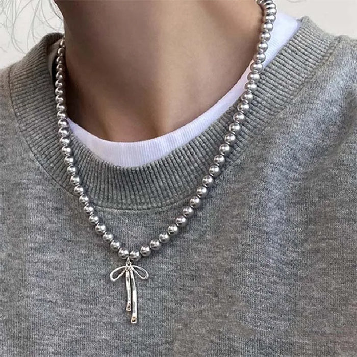 Collier de perles avec pendentif en forme de nœud